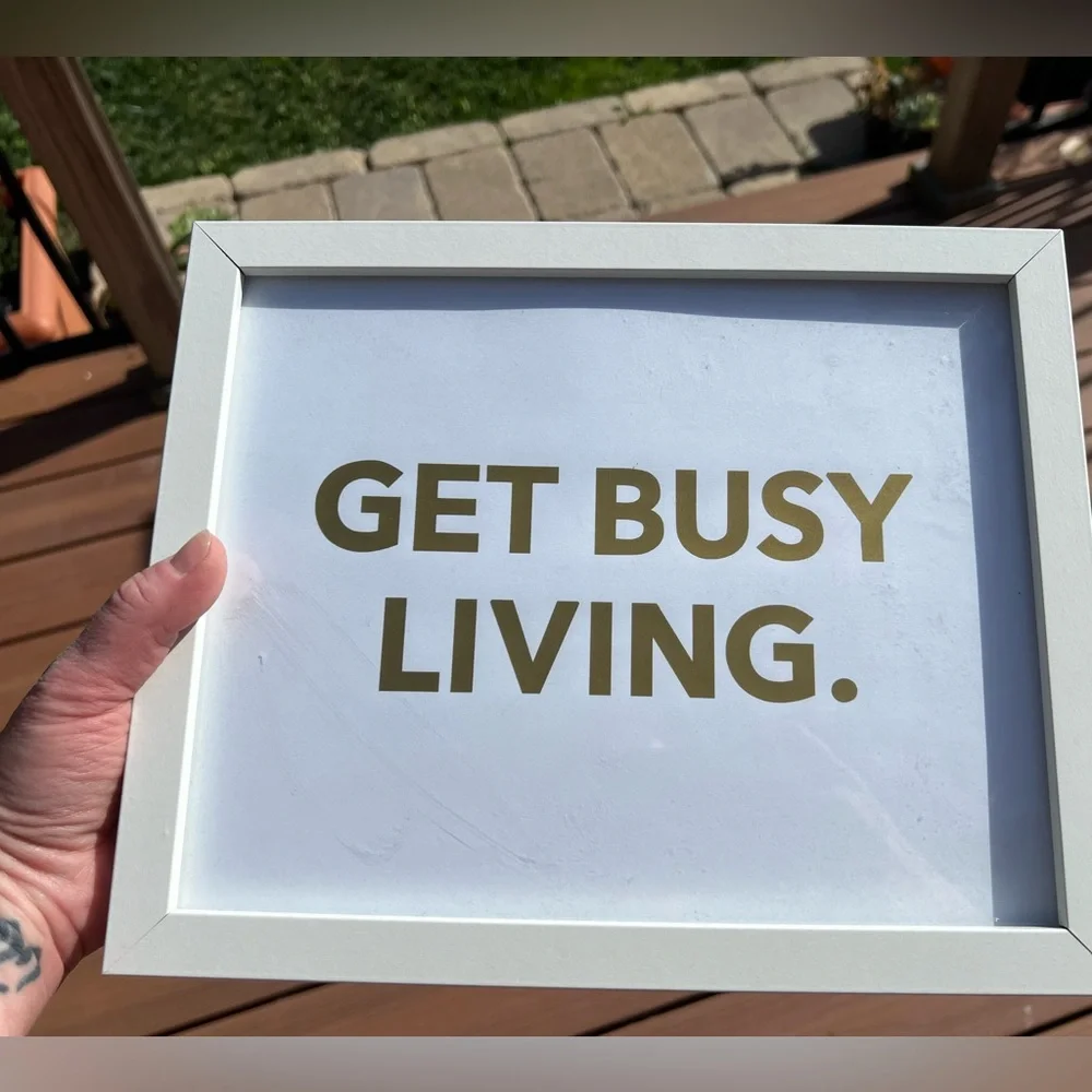 9x11” framed ‘get busy living’ saying in gold font.